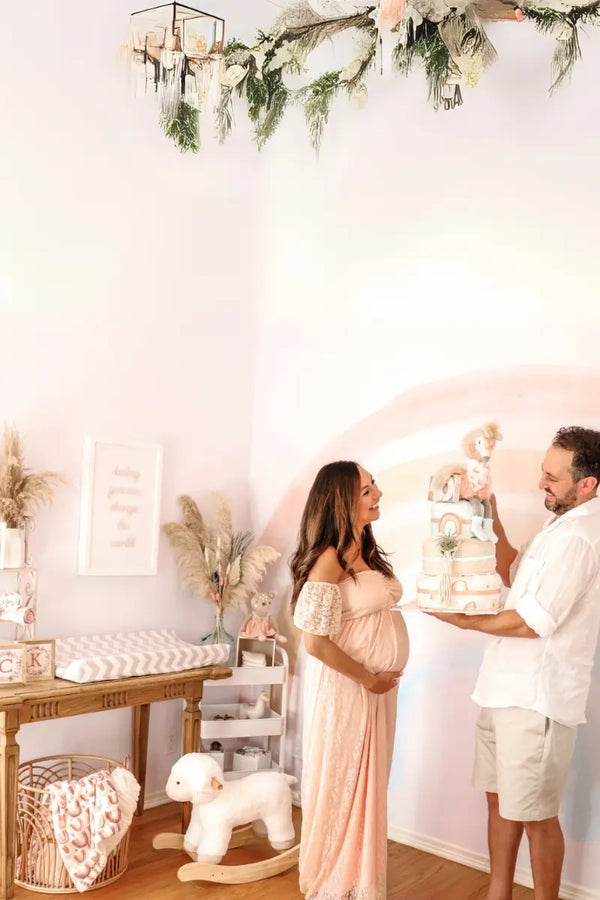 Baby gift arrangements featuring a cozy nursery setup with plush toys, a diaper cake, and pastel decor.
