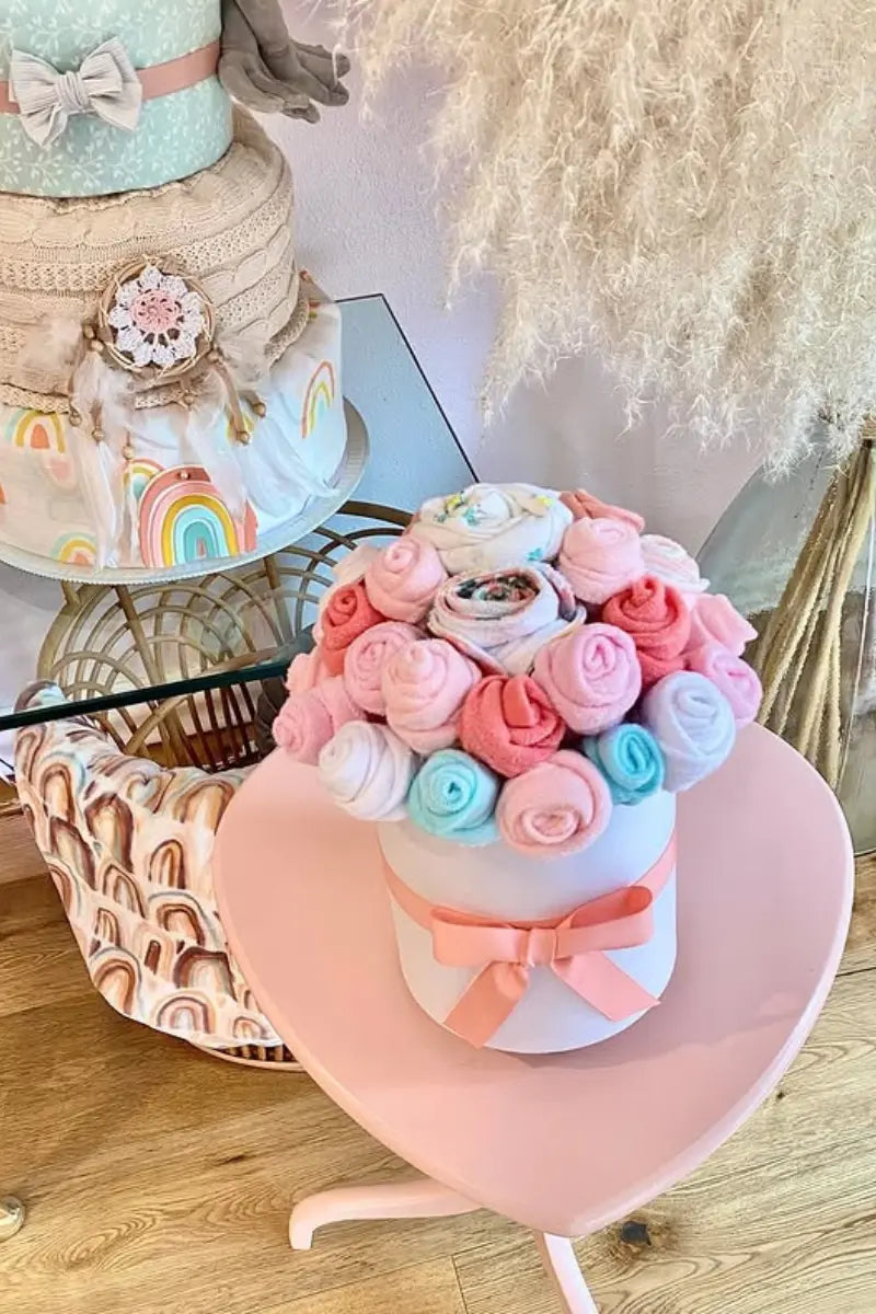 Diaper cake bouquets featuring rolled baby essentials arranged like colorful flower blooms for a charming baby gift.
