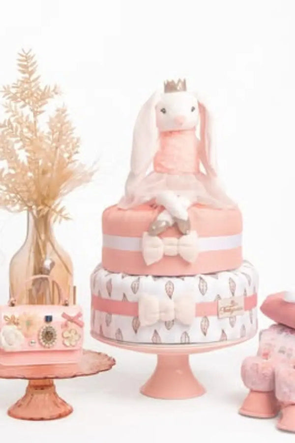 Diaper cakes stacked with soft fabrics, plush toys, and delicate bows for an elegant baby shower centerpiece.