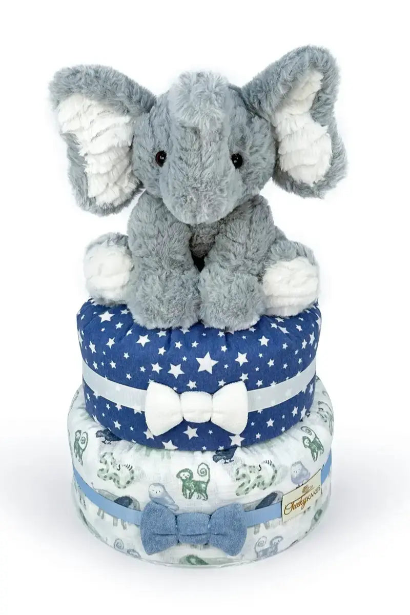 Elephant diaper tower featuring a plush gray elephant sitting atop a two-tiered diaper cake decorated with ribbons and fabric.