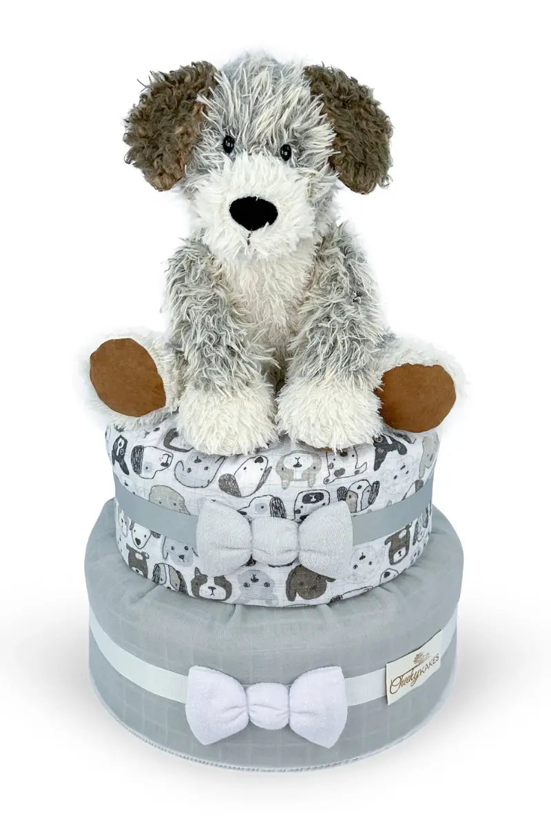 Themed diaper cakes with a plush dog atop layered gray and white fabric decorated with bows.